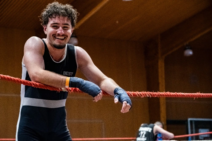 Personne qui s'appuie sur les cordes d'un ring de boxe